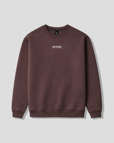 Oversized women's crewneck in dark brown with a white 'LYFTLYFE' logo on the chest on a light gray background. 
