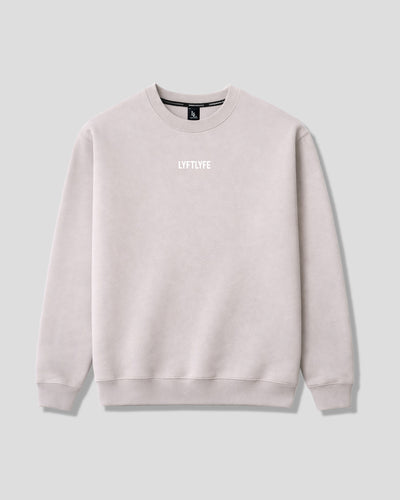 Oversized women's crewneck in off-white with a brand logo on a light gray background