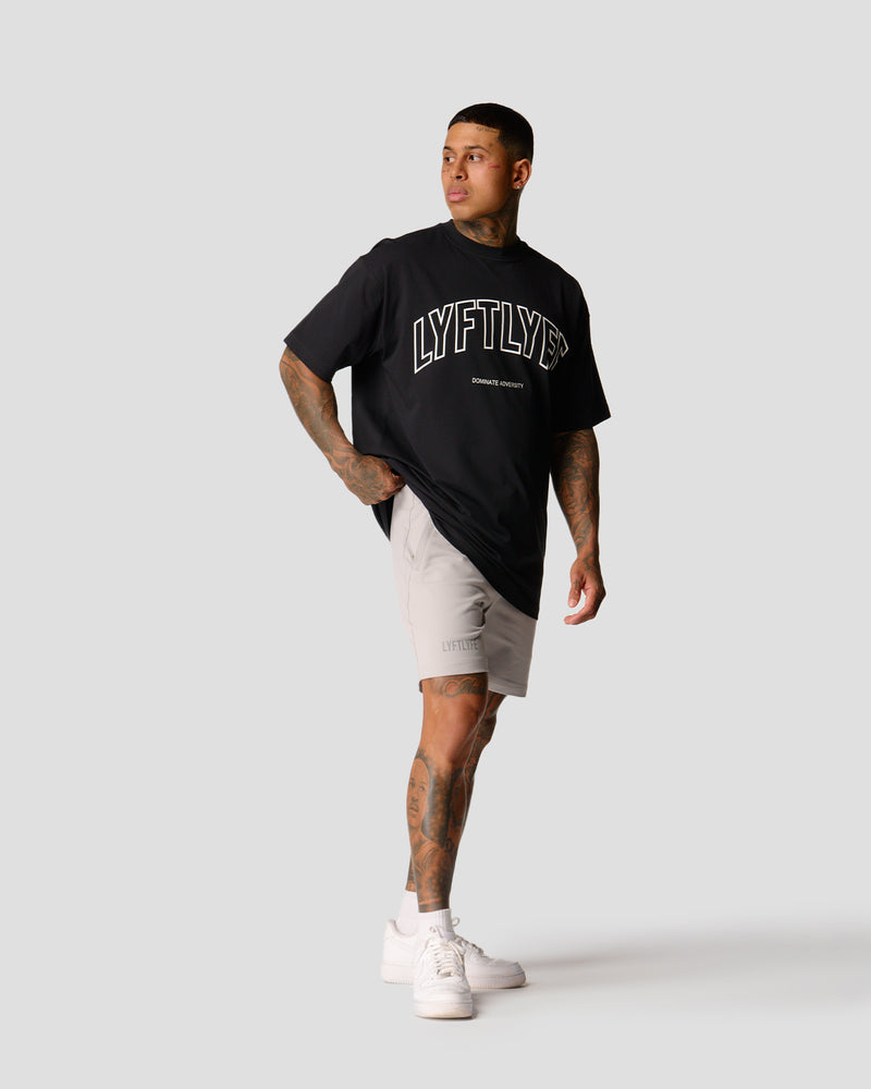 A male athlete is in a black oversized T-shirt with a large lyftlyfe logo on the chest.