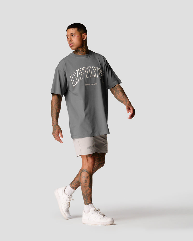 A male athlete is in a gray oversized T-shirt with a large lyftlyfe logo on the chest.