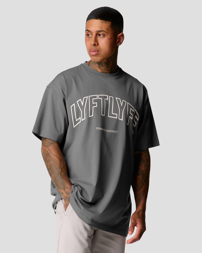 A male athlete is in a gray oversized T-shirt with a large lyftlyfe logo on the chest.