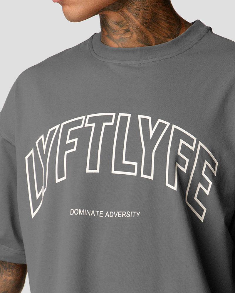 A male athlete is in a gray oversized T-shirt with a large lyftlyfe logo on the chest.