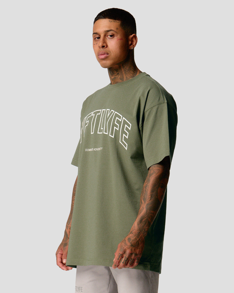 A male athlete is in a green oversized T-shirt with a large lyftlyfe logo on the chest.