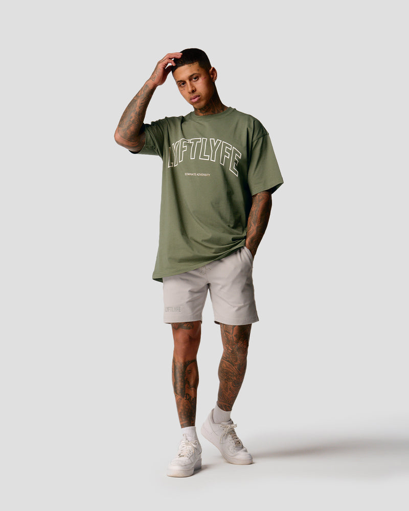 A male athlete is in a green oversized T-shirt with a large lyftlyfe logo on the chest.