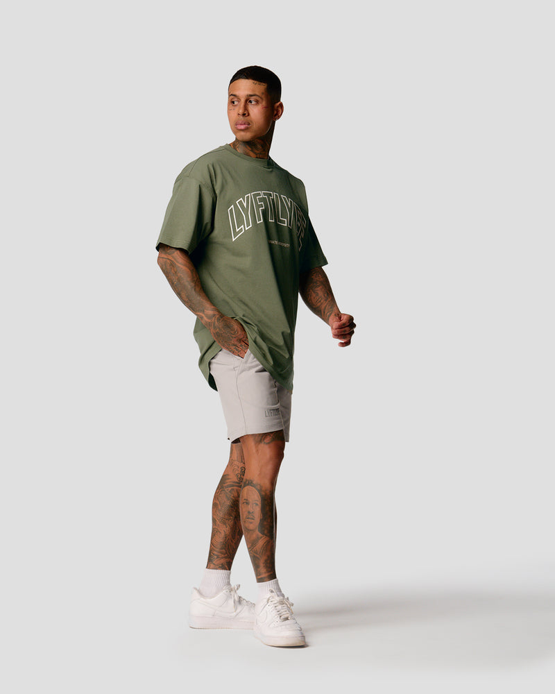 A male athlete is in a green oversized T-shirt with a large lyftlyfe logo on the chest.