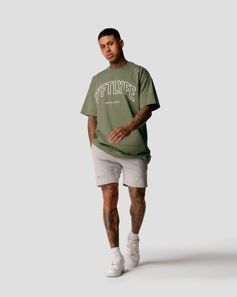 A male athlete is in a green oversized T-shirt with a large lyftlyfe logo on the chest.