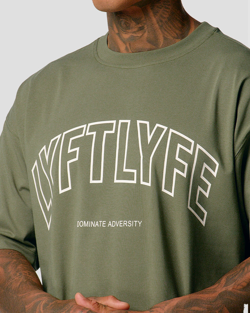 A male athlete is in a green oversized T-shirt with a large lyftlyfe logo on the chest.