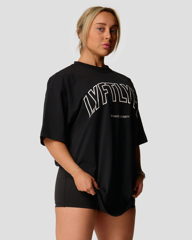 A female athlete is in a black oversized T-shirt with a large lyftlyfe logo on the chest.