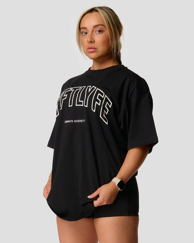 A female athlete is in a black oversized T-shirt with a large lyftlyfe logo on the chest.