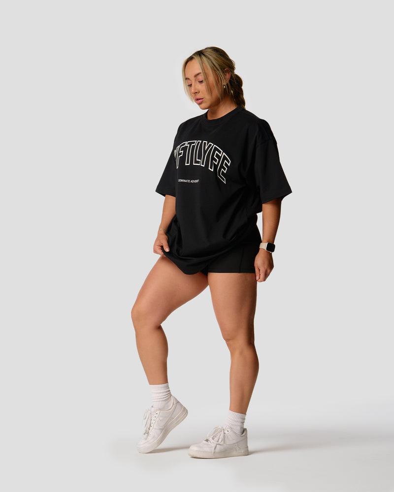 A female athlete is in a black oversized T-shirt with a large lyftlyfe logo on the chest.