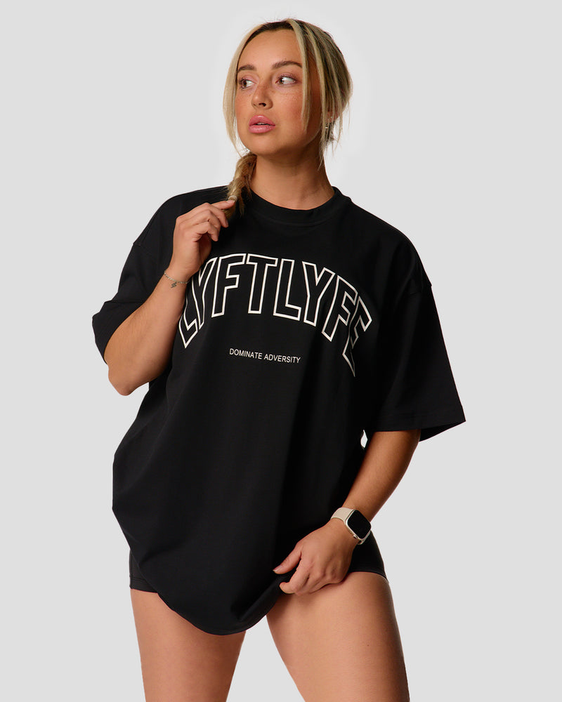 A female athlete is in a black oversized T-shirt with a large lyftlyfe logo on the chest.