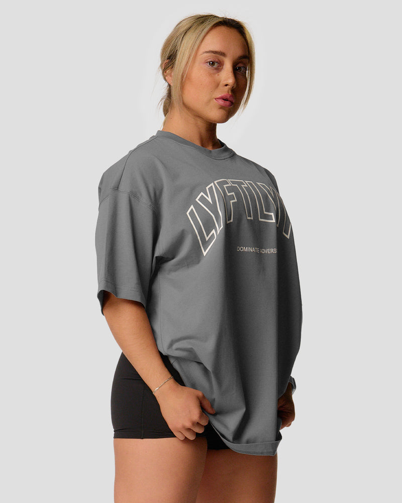 A female athlete is in a gray oversized T-shirt with a large lyftlyfe logo on the chest.