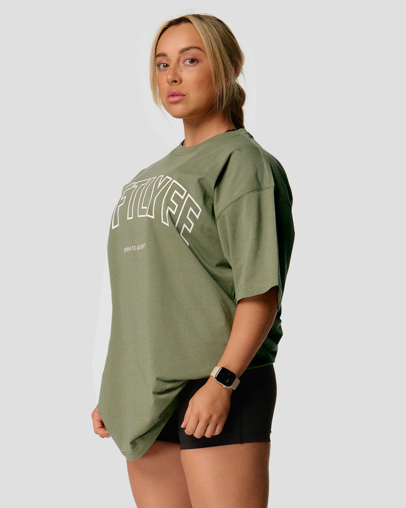 A female athlete is wearing a r, oversized T-shirt featuring a large lyftlyfe logo across the chest.green