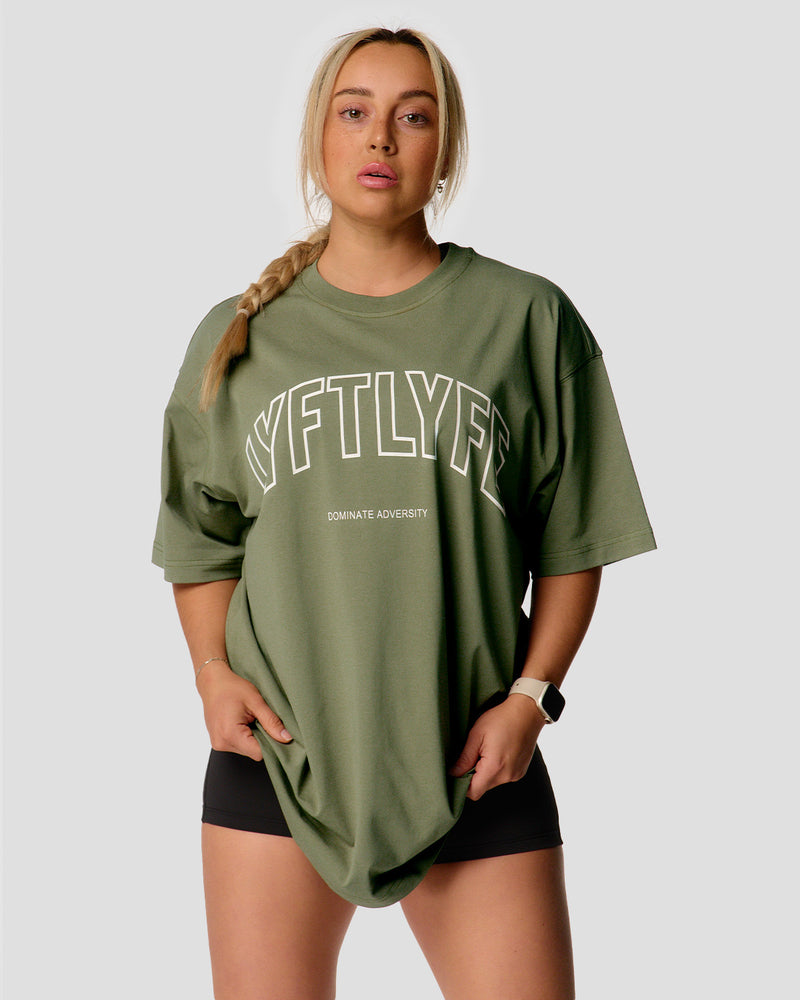 A female athlete is wearing a r, oversized T-shirt featuring a large lyftlyfe logo across the chest.green