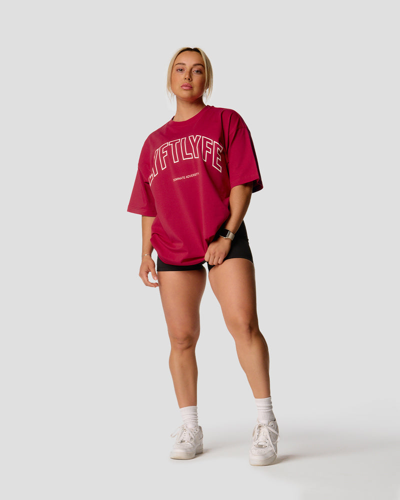 A female athlete is wearing a red, oversized T-shirt featuring a large lyftlyfe logo across the chest.