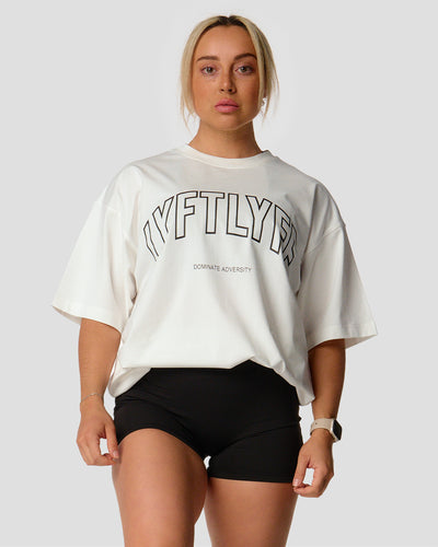 A female athlete is in a white oversized T-shirt with a large lyftlyfe logo on the chest.