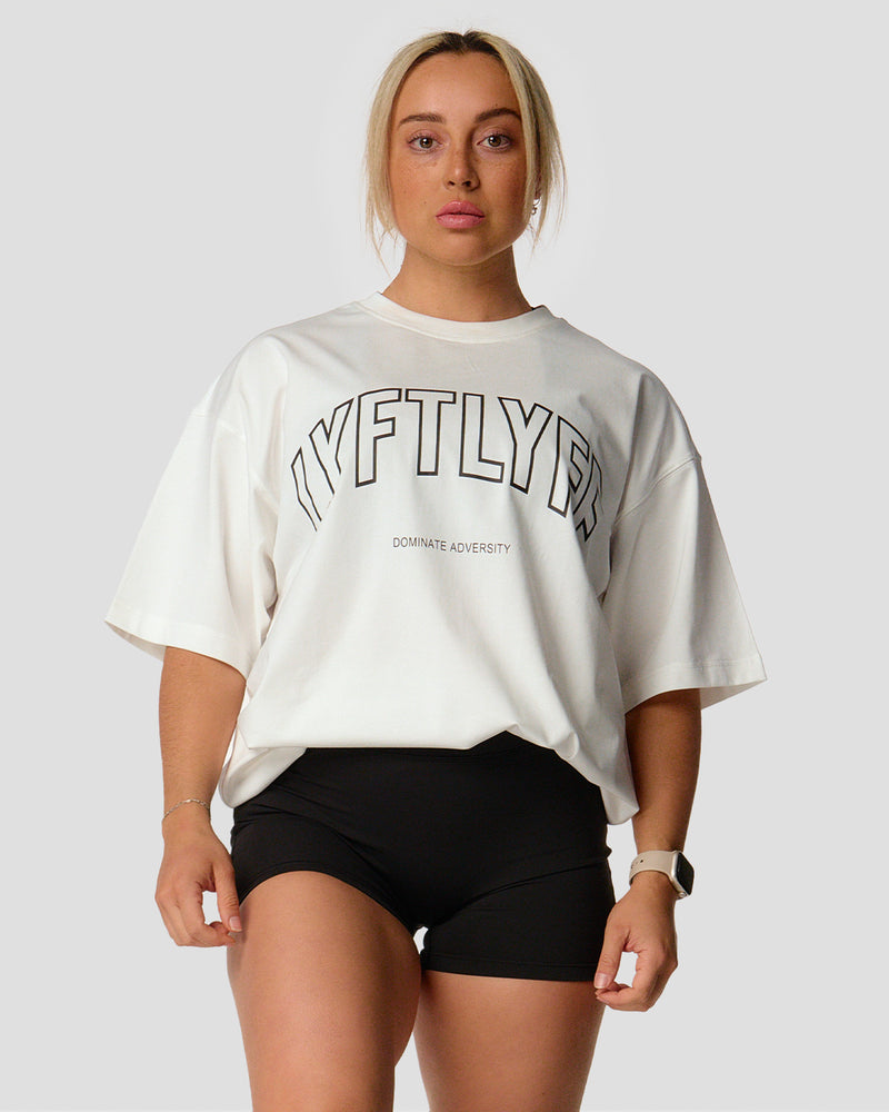 A female athlete is in a white oversized T-shirt with a large lyftlyfe logo on the chest.