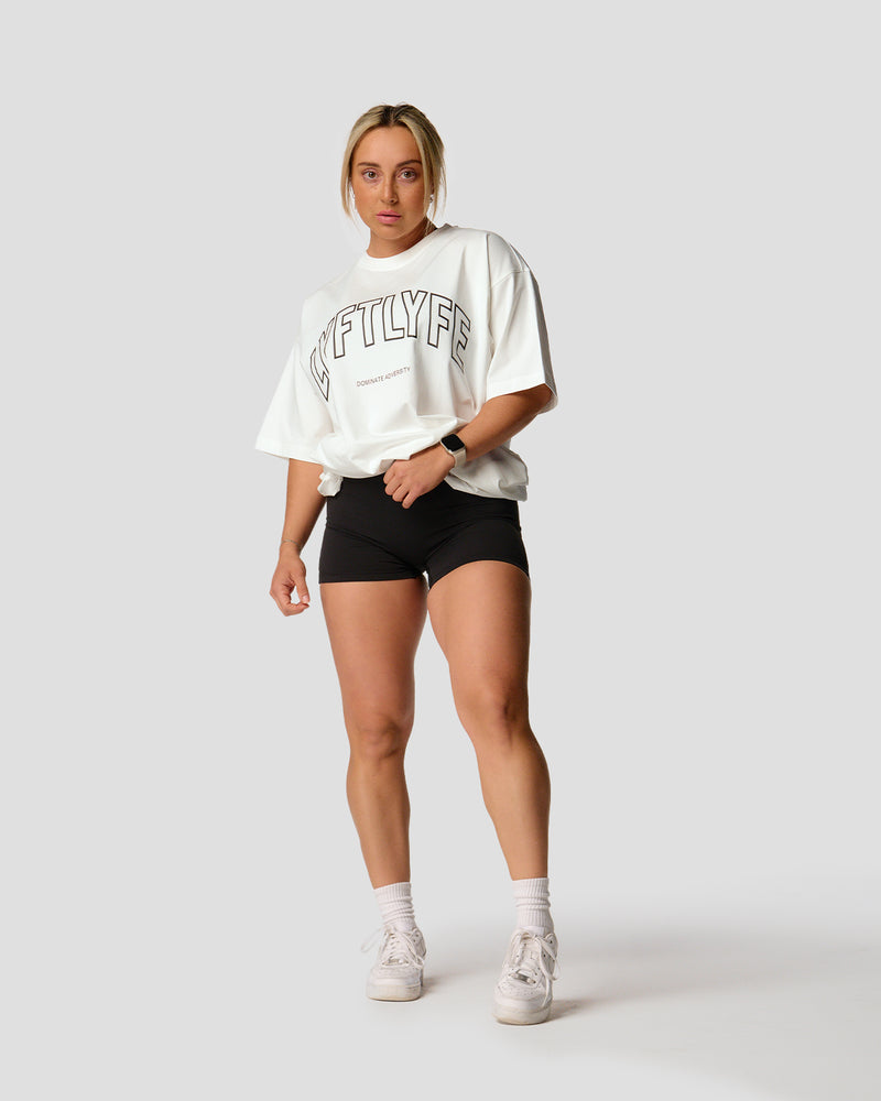 A female athlete is in a white oversized T-shirt with a large lyftlyfe logo on the chest.