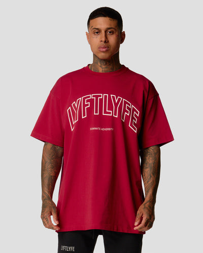 Red oversized men’s T-shirt with bold Lyftlyfe branding and empowering 'Dominate Adversity' slogan.