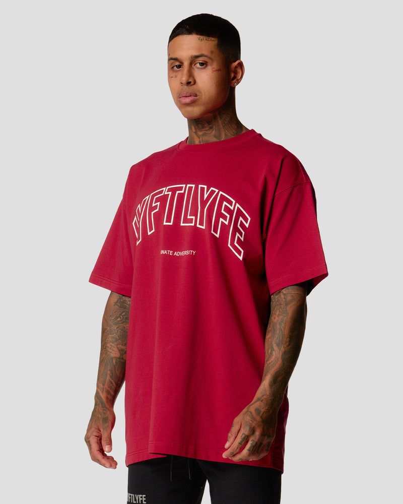 A male athlete is wearing a red, oversized T-shirt featuring a large lyftlyfe logo across the chest.