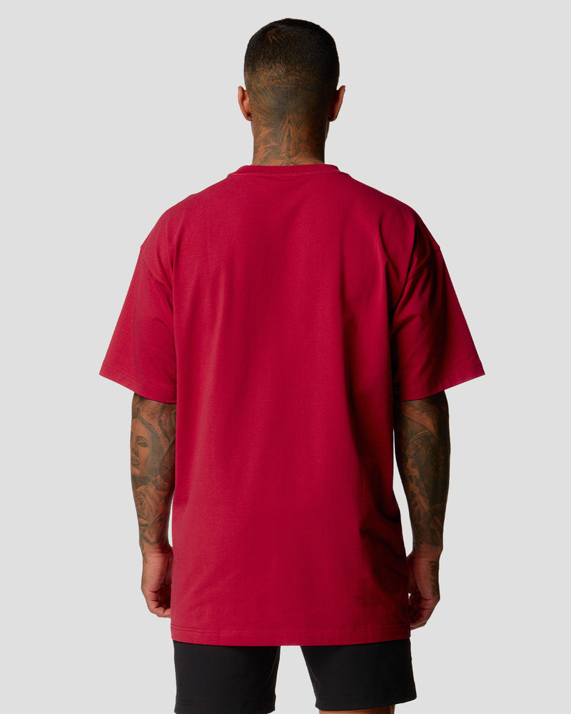 A male athlete is wearing a red, oversized T-shirt featuring a large lyftlyfe logo across the chest.