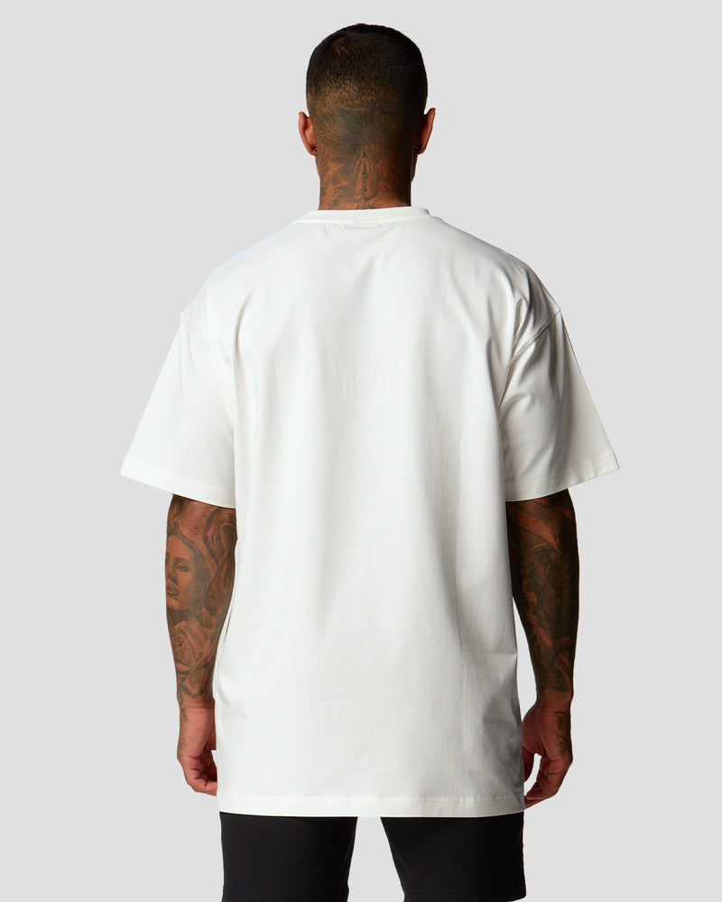 A male athlete is wearing a white, oversized T-shirt featuring a large lyftlyfe logo across the chest.