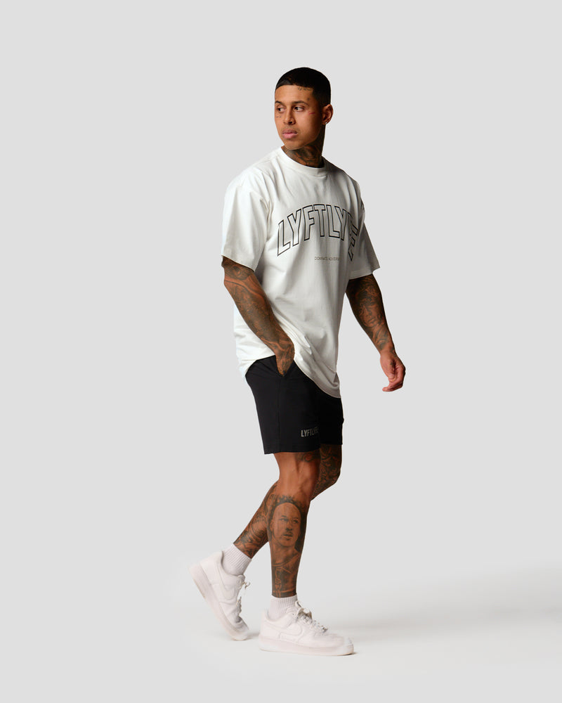 A male athlete is wearing a white, oversized T-shirt featuring a large lyftlyfe logo across the chest.