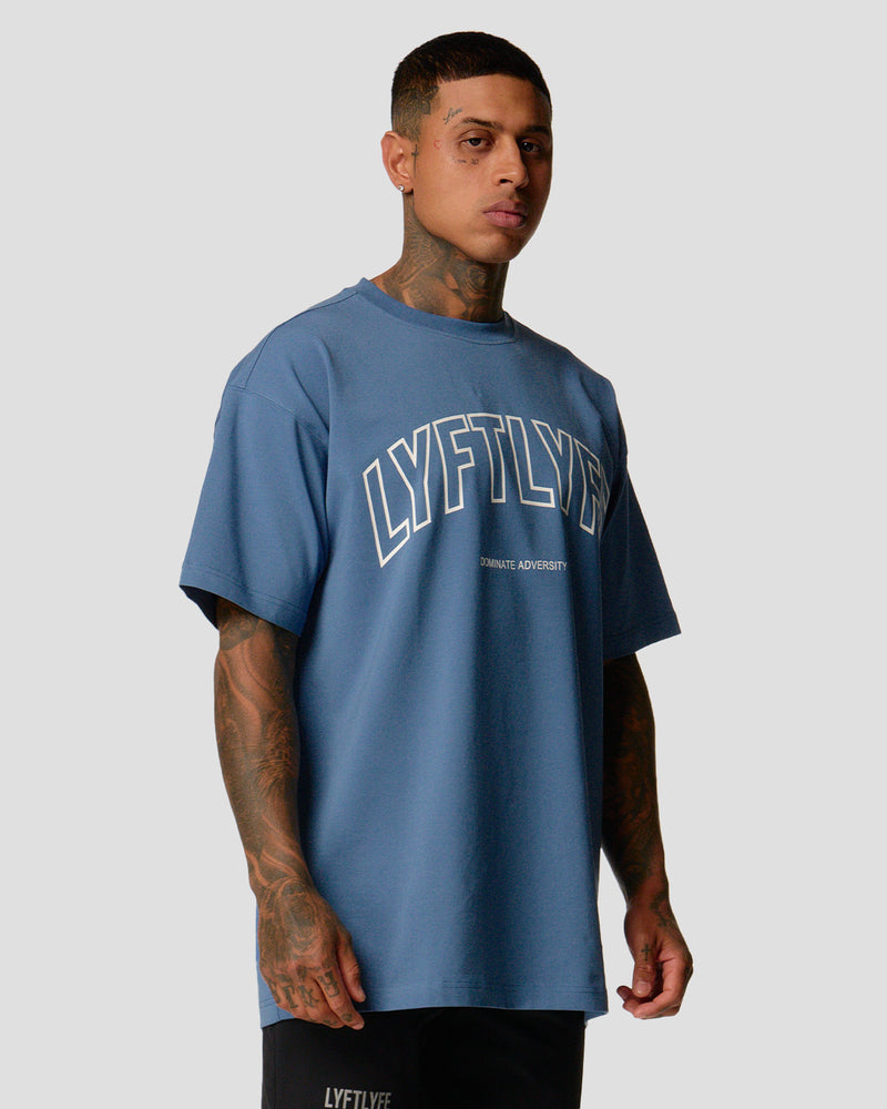 A male athlete is in a blue oversized T-shirt with a large lyftlyfe logo on the chest.