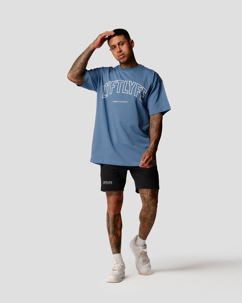 A male athlete is in a blue oversized T-shirt with a large lyftlyfe logo on the chest.