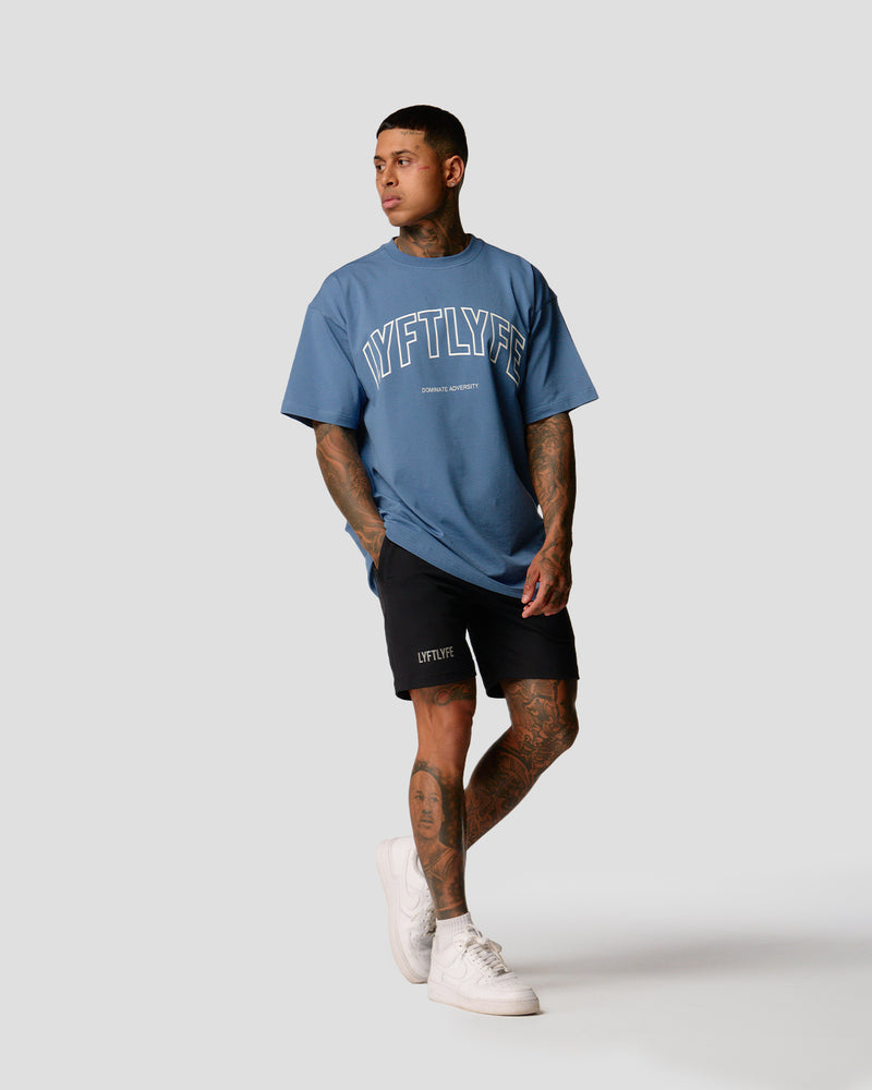 A male athlete is in a blue oversized T-shirt with a large lyftlyfe logo on the chest.