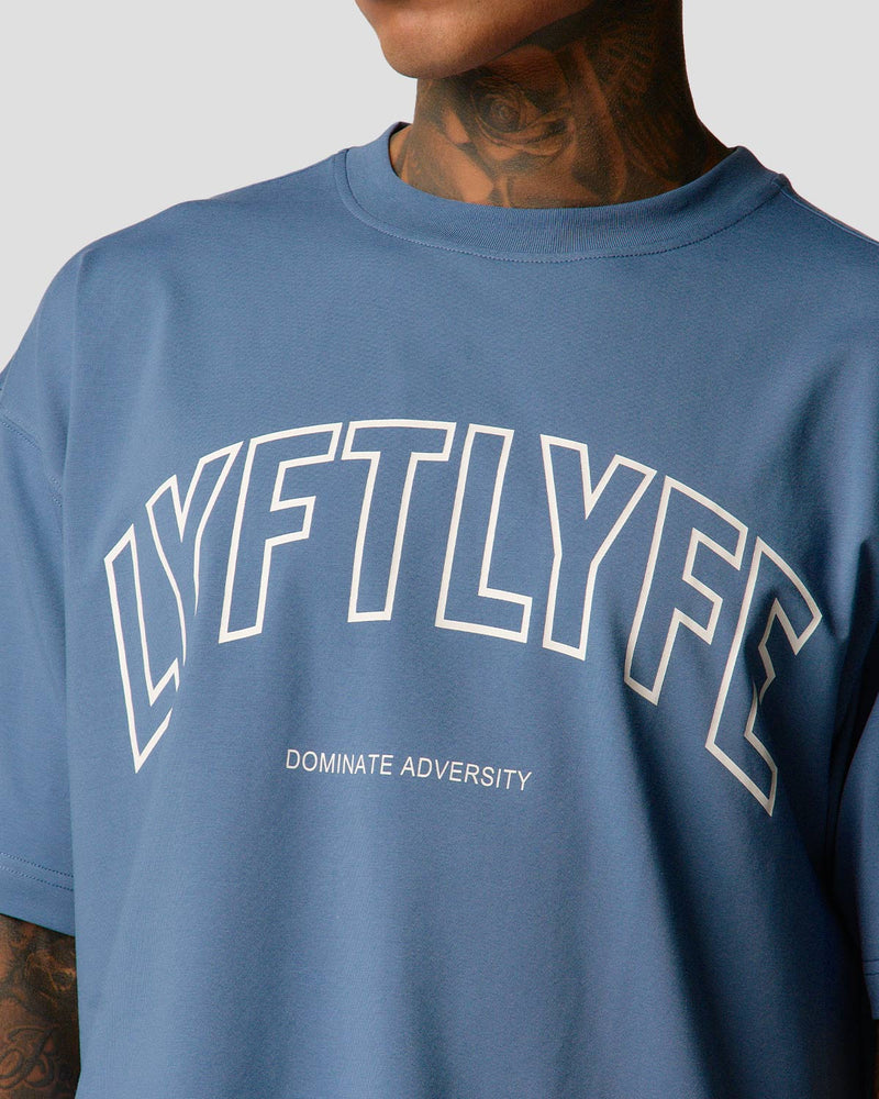 A male athlete is in a blue oversized T-shirt with a large lyftlyfe logo on the chest.