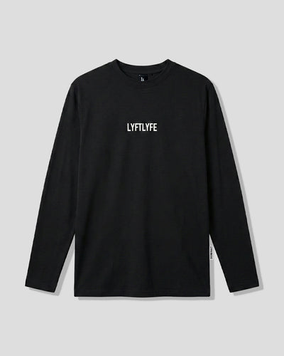 Men’s black LYFTLYFE essential long sleeve shirt with white chest logo on light grey background.