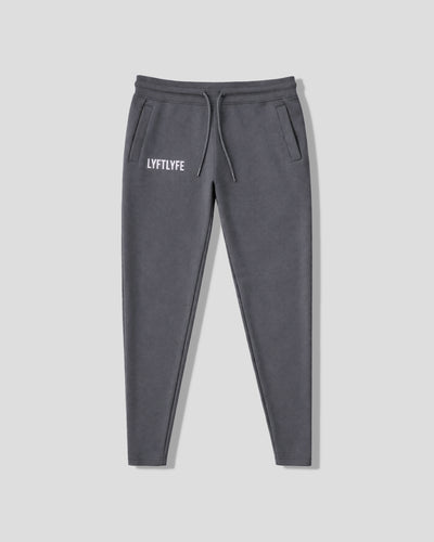Charcoal grey sweatpants with 'LYFTLYFE' logo on a light gray background