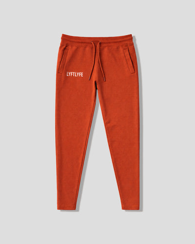 Cherry red sweatpants with a white LYFTLYFE logo on a gray background