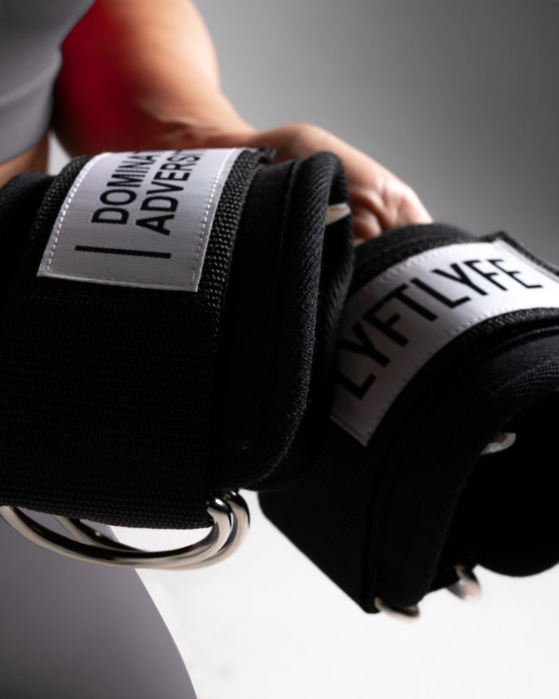 Person wearing white sneakers with black ankle bands displaying motivational phrases on a light gray background.