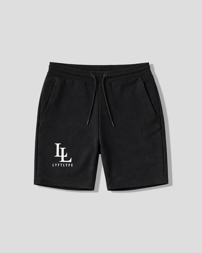 Black gym shorts with a logo on a light gray background