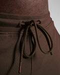 Zoomed view of men's gym shorts waistband with tonal drawstrings and metal tips in dark brown.