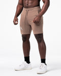Men’s workout shorts in taupe viewed from the right side, featuring clean stitch lines and deep pockets.