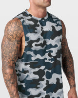 Detailed view of chest logo on blue camo sleeveless gym top with high-tech fabric finish.