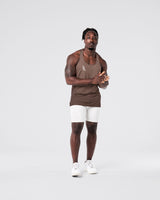 Full body fit of brown gym stringer and light grey shorts.