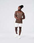 Head-to-toe look with brown gym stringer and light grey shorts.
