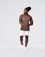 Head-to-toe look with brown gym stringer and light grey shorts.