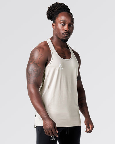 Beige tank top with a logo on a light gray background