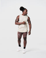 Limitless Men’s Cut Sleeve in off-white, with reflective chest logo, scalloped hem, and wide shoulder cut.