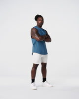 Side view of Limitless Men’s Cut Sleeve in dark blue, with reflective chest logo, scalloped hem, and wide shoulder cut.