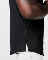 Detail view of signature Lyftlyfe side flag tag on split hem of Limitless Cut Sleeve tank in black.