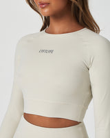 Close-up of LYFTLYFE reflective logo on the chest of the Force Long Sleeve Crop in Vapor White.