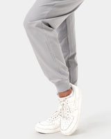 Close-up of the 'Dominate Adversity' slogan printed on the lower leg of women’s light grey Breathe Joggers, showcasing attention to detail.