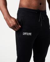 Close-up of men’s black Breathe Joggers, highlighting the invisible side pocket with locking zipper and Lyftlyfe reflective logo.