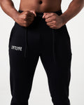 Close-up of black Breathe Joggers, showing elastic waistband, tonal drawstring, and Lyftlyfe reflective logo on the left thigh.